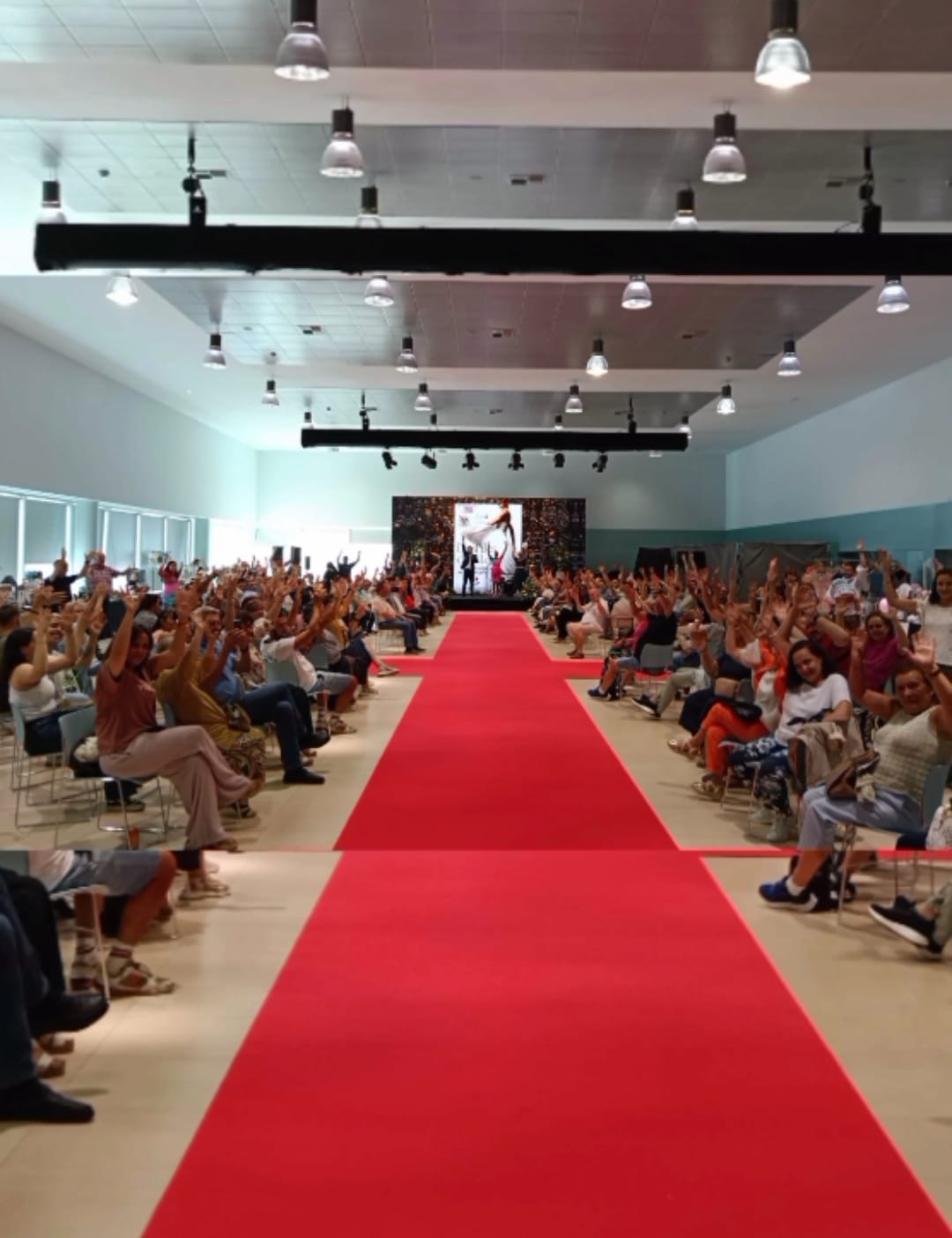 Desfile de moda con pasarela llena de público